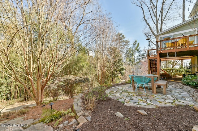 view of yard with a patio, stairway, outdoor dining area, and a wooden deck