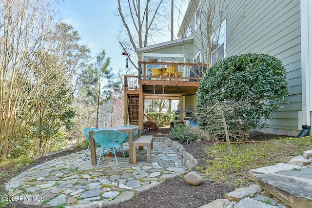 view of patio with stairs, outdoor dining area, and a wooden deck