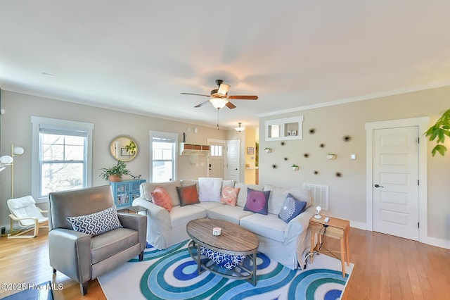 living area featuring visible vents, baseboards, light wood-type flooring, and a ceiling fan