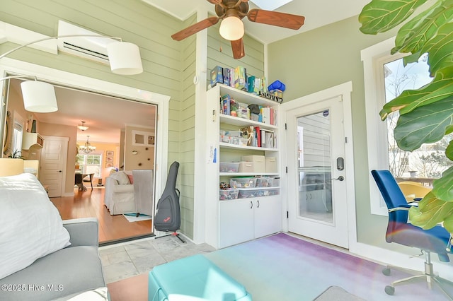 interior space featuring wood walls and ceiling fan with notable chandelier