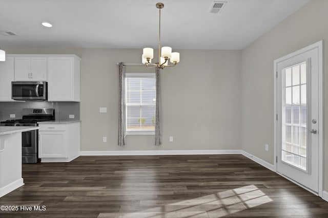 kitchen with visible vents, dark wood-style flooring, white cabinets, appliances with stainless steel finishes, and backsplash