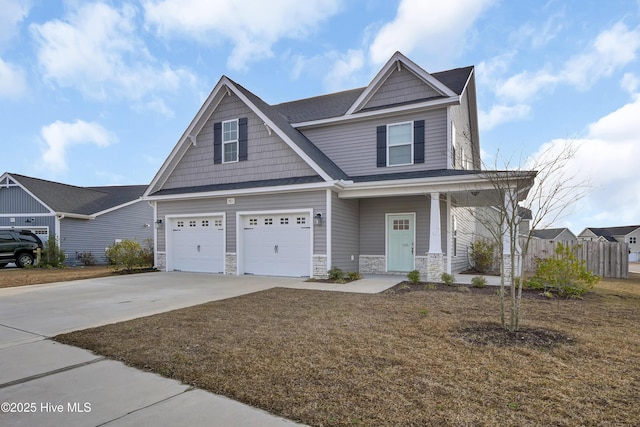 craftsman-style home with concrete driveway, an attached garage, covered porch, and stone siding