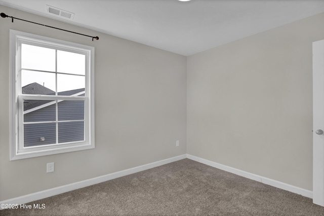 carpeted empty room with visible vents and baseboards