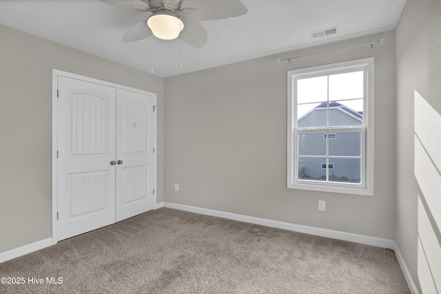 unfurnished bedroom featuring visible vents, baseboards, a closet, and carpet flooring