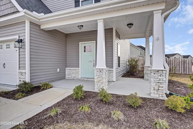 property entrance with stone siding, a porch, fence, roof with shingles, and a garage