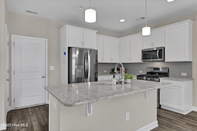 kitchen featuring a sink, visible vents, appliances with stainless steel finishes, and dark wood-style flooring