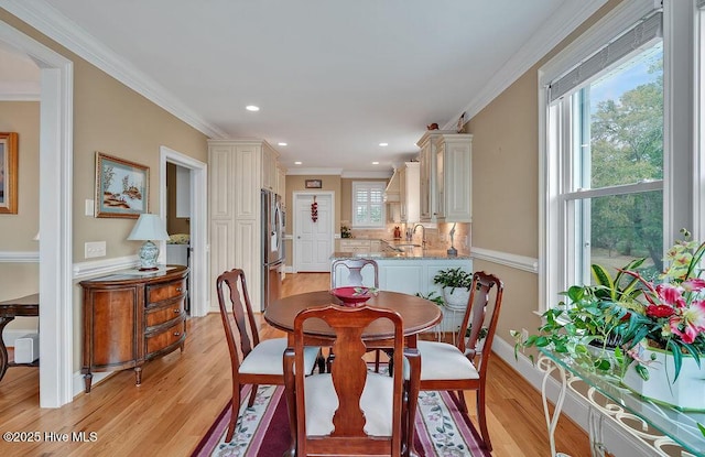 dining room featuring light wood-style flooring, baseboards, ornamental molding, and recessed lighting
