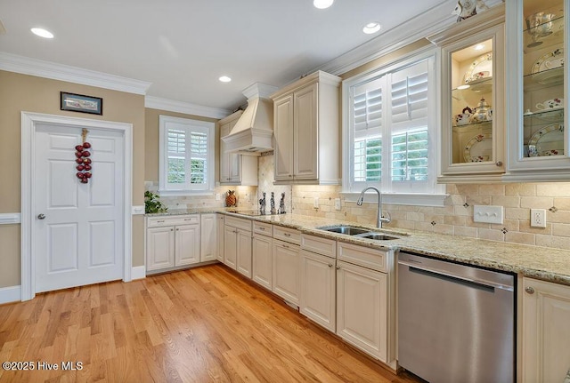 kitchen featuring stainless steel dishwasher, ornamental molding, a healthy amount of sunlight, a sink, and custom range hood