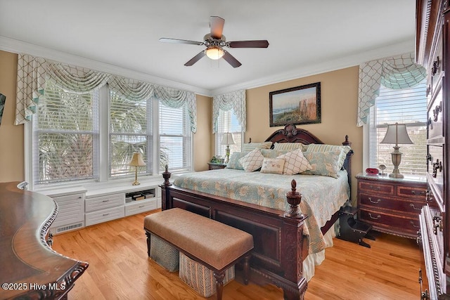 bedroom featuring crown molding, light wood-style flooring, a ceiling fan, and visible vents