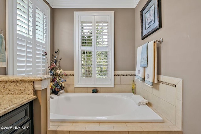 bathroom with vanity, ornamental molding, and a garden tub