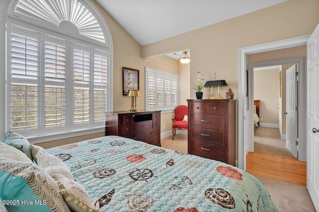 bedroom with vaulted ceiling, carpet floors, and baseboards