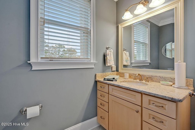 bathroom with a wealth of natural light, vanity, and crown molding