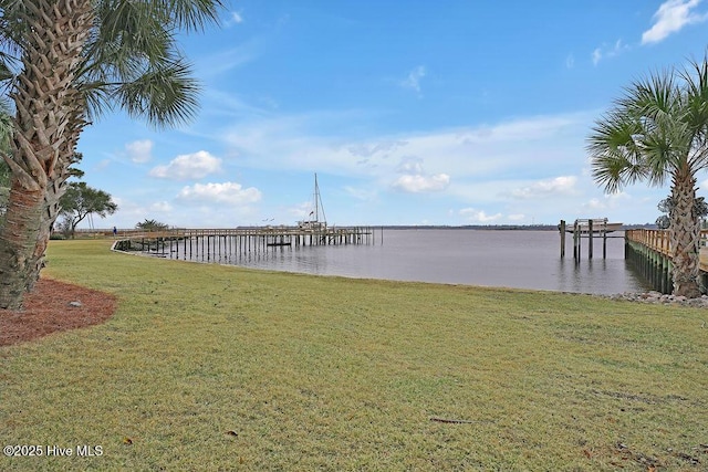 view of dock featuring a water view and a lawn