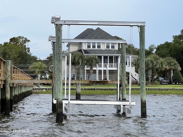 back of house with a water view, stairway, and boat lift