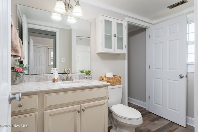 bathroom featuring wood finished floors, vanity, baseboards, toilet, and visible vents