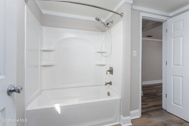 bathroom featuring shower / bathing tub combination, wood finished floors, and baseboards