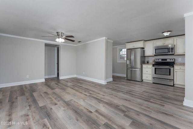 kitchen with ceiling fan, baseboards, wood finished floors, and appliances with stainless steel finishes