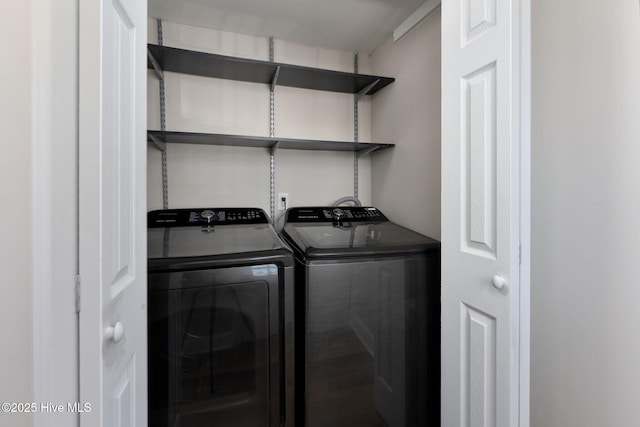 clothes washing area featuring separate washer and dryer and laundry area