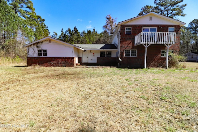 back of house featuring a yard and brick siding