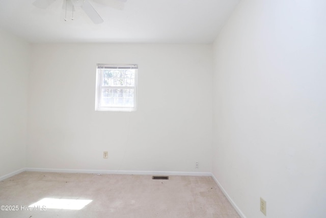 spare room with light carpet, baseboards, visible vents, and ceiling fan