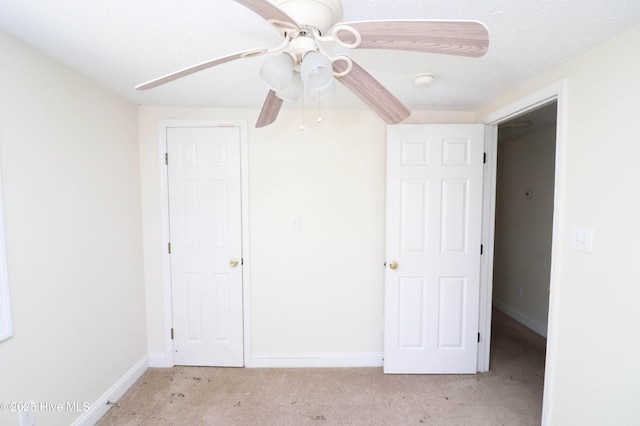 unfurnished bedroom with baseboards, light colored carpet, and a ceiling fan