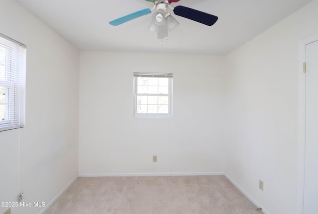 spare room with baseboards, light colored carpet, and ceiling fan