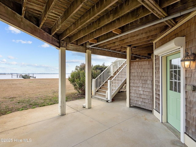 view of patio / terrace with a water view and stairs