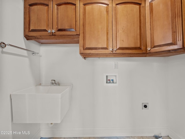 laundry room with baseboards, washer hookup, cabinet space, electric dryer hookup, and a sink