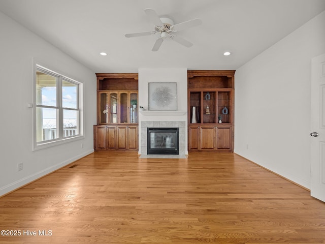 unfurnished living room featuring visible vents, light wood-style flooring, a tiled fireplace, recessed lighting, and ceiling fan