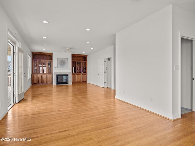 unfurnished living room featuring recessed lighting, a fireplace, light wood-style floors, and ceiling fan