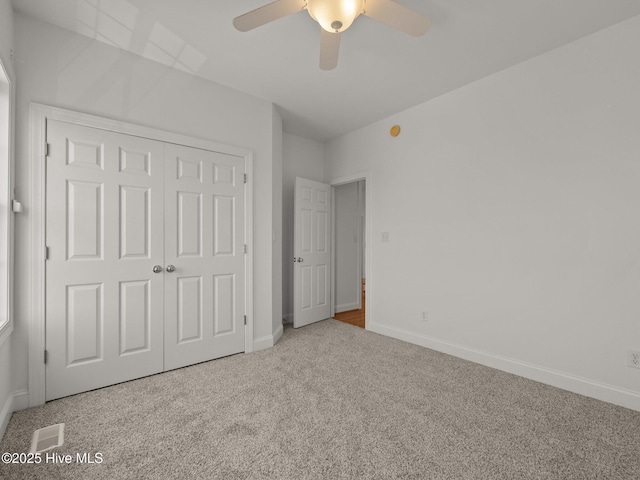 unfurnished bedroom featuring visible vents, a ceiling fan, a closet, carpet, and baseboards