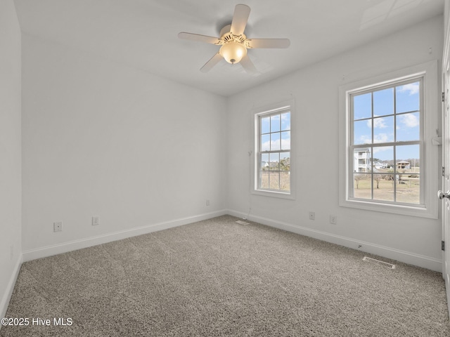 carpeted empty room featuring visible vents, baseboards, and a ceiling fan