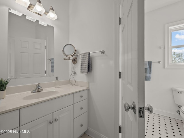 bathroom featuring vanity, toilet, and baseboards