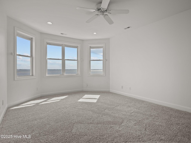 unfurnished room with recessed lighting, visible vents, carpet floors, and baseboards