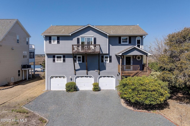 view of front of home featuring aphalt driveway, a balcony, and an attached garage