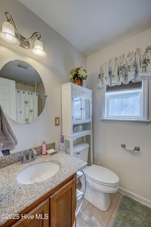 bathroom with vanity, tile patterned floors, toilet, and baseboards