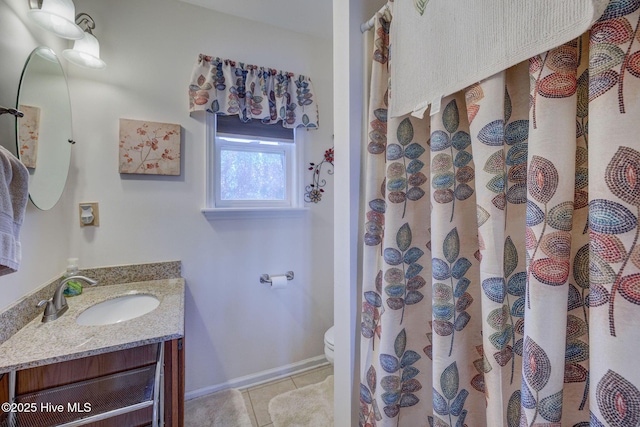 bathroom with tile patterned floors, baseboards, toilet, and vanity