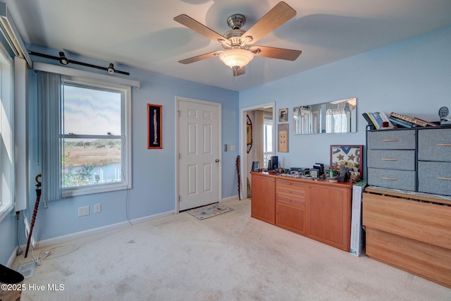 unfurnished office with light colored carpet, baseboards, and ceiling fan