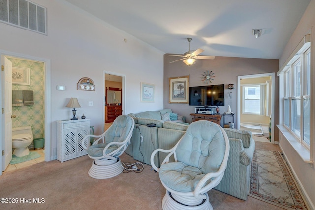 carpeted living room with visible vents, ceiling fan, and vaulted ceiling