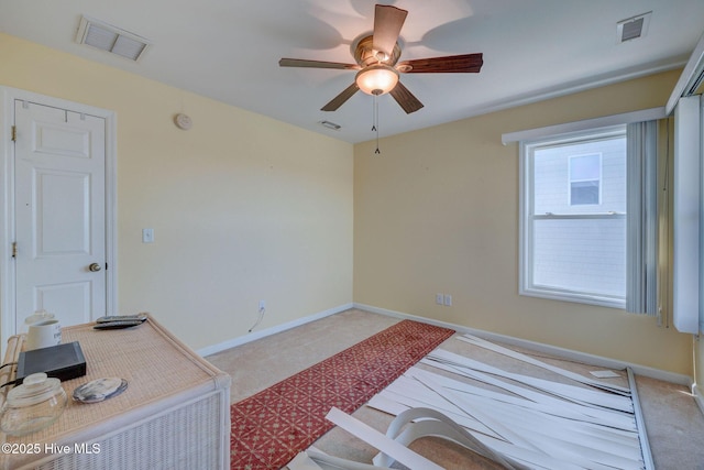 interior space with baseboards, light colored carpet, visible vents, and ceiling fan