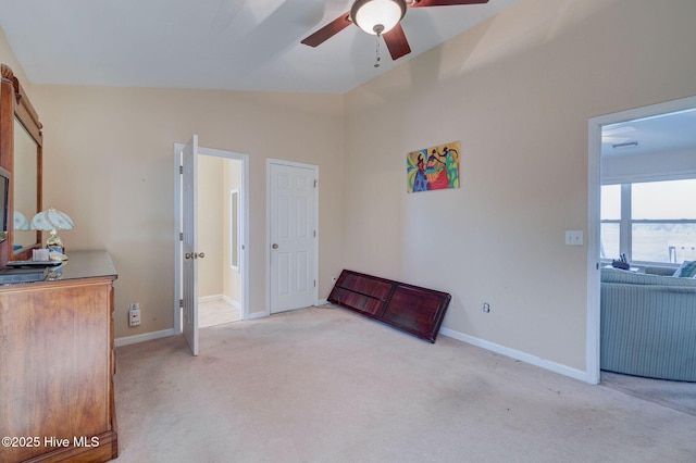 sitting room featuring carpet flooring, baseboards, ceiling fan, and vaulted ceiling