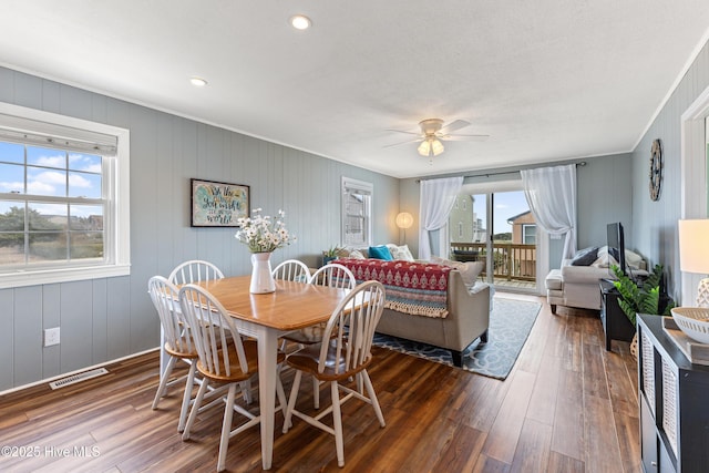 dining room featuring dark wood-style floors, visible vents, and ceiling fan