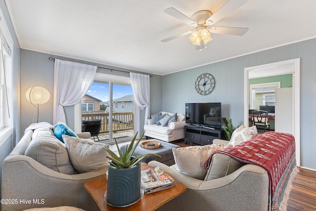 living area with crown molding, ceiling fan, and wood finished floors