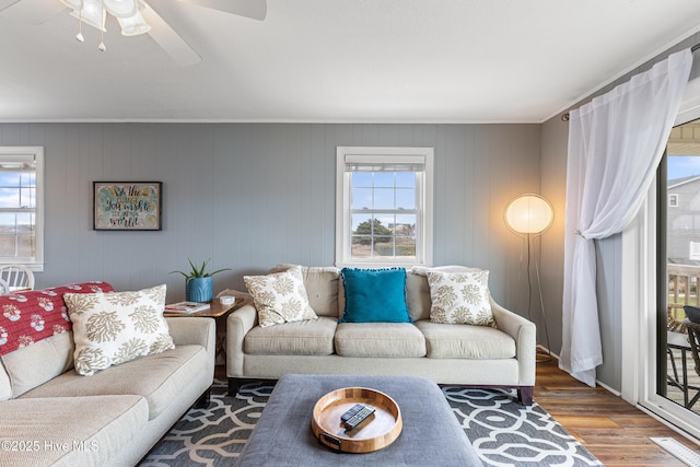 living room featuring visible vents, ornamental molding, ceiling fan, and wood finished floors