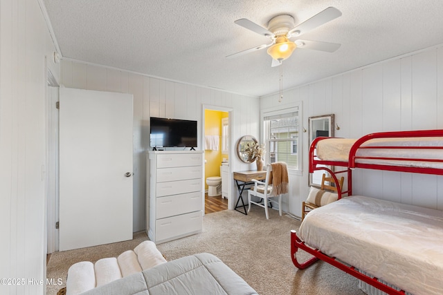 bedroom with ceiling fan, carpet flooring, connected bathroom, and a textured ceiling