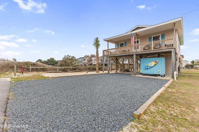 coastal home with stairs, driveway, a carport, and volleyball court