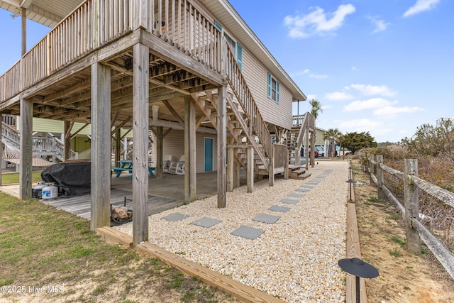 view of home's exterior with a patio, stairway, and fence