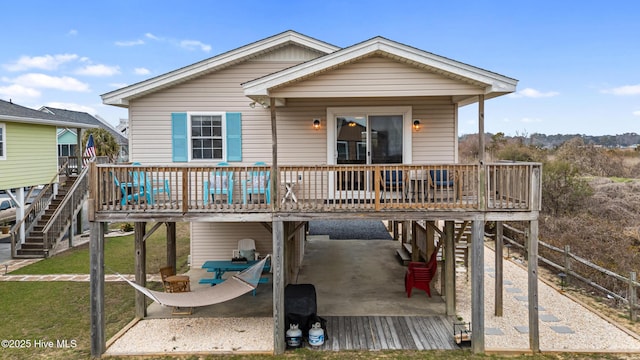 back of house with a deck, a yard, a carport, stairs, and a patio area