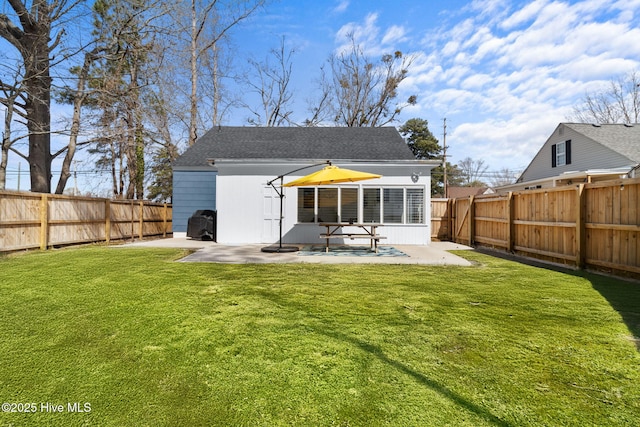 back of property with a fenced backyard, a patio, and a yard