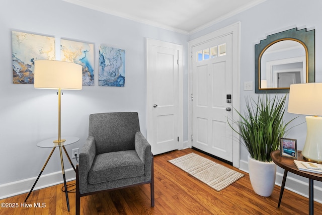 foyer entrance featuring baseboards, crown molding, and wood finished floors